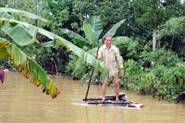 Phương tiên đi lại, sinh hoạt của người dân vùng mưa lũ là chiếc bè được ghép bằng những cây chuối. (Ảnh: Phan Quân/TTXVN) 