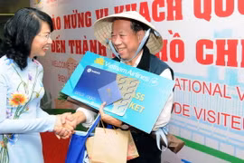 Bà Nguyễn Thị Thu, Phó Chủ tịch Ủy ban Nhân dân Thành phố chúc mừng ông Chappe Bertrand (Quốc tịch Pháp) là vị khách thứ 5 triệu đi trên chuyến bay VN10 từ Pháp đến Thành phố Hồ Chí Minh. (Ảnh: An Hiếu/TTXVN)