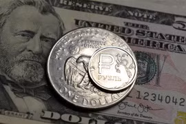 Đồng xu ruble của Nga (trên) và đồng đôla Mỹ. (Ảnh: AFP/TTXVN)