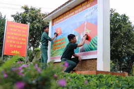 Các chiến sỹ Đồn Biên phòng Huổi Luông (Lai Châu) chỉnh trang lại bức cổ động bầu cử. (Ảnh: Nguyễn Oanh/TTXVN)