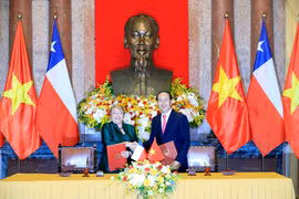 Chủ tịch nước Trần Đại Quang và Tổng thống nước Cộng hòa Chile Michelle Bachelet Jeria ký Tuyên bố chung. (Ảnh: Nhan Sáng/TTXVN)
