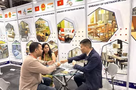 Đại diện Thương vụ Việt Nam tại Ấn Độ trao đổi thông tin với khách tham quan Triển lãm Đồ gỗ Nội thất Quốc tế tại gian trưng bày sản phẩm của Việt nam. (Ảnh: Ngọc Thúy/TTXVN)
