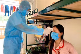 Đo thân nhiệt cho người dân trong khu cách ly trường quân sự Sơn Tây. (Ảnh: TTXVN phát)