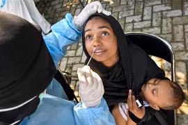 Nhân viên y tế lấy mẫu xét nghiệm COVID-19 cho người dân tại tỉnh Aceh, Indonesia. (Ảnh: AFP/TTXVN)