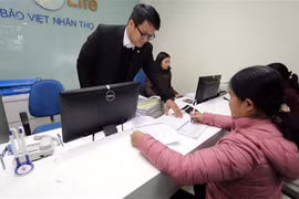 Khách hàng giao dịch tại một chi nhánh bảo hiểm nhân thọ. (Ảnh: Trần Việt/TTXVN)