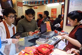 Khách hàng đang giao dịch vàng miếng. (Ảnh: Đức Duy/Vietnam+)