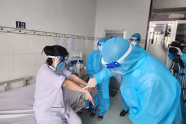 Lãnh đạo Cục Y tế dự phòng thăm hỏi, động viên người bệnh mắc đậu mùa khỉ đầu tiên tại Việt Nam. (Ảnh: TTXVN phát)