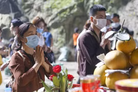 Du khách đến dâng lễ tại động Hương Tích tuân thủ việc đeo khẩu trang phòng dịch. (Ảnh: Tuấn Đức/TTXVN)