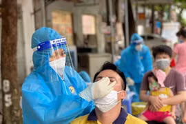 Nhân viên y tế lấy mẫu xét nghiệm cho người dân tại Hà Nội. (Ảnh: PV/Vietnam+)