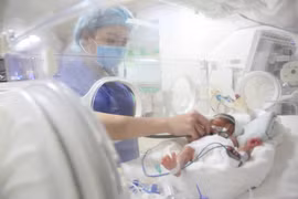 Nhân viên y tế chăm sóc cho trẻ sơ sinh. (Ảnh: PV/Vietnam+)