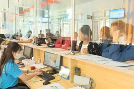 Nhân viên của Bảo hiểm Xã hội Việt Nam giải quyết các thủ tục cho người dân. (Ảnh: Việt Hoàng/TTXVN)