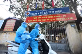 Nhân viên y tế xã kết hợp cùng trạm y tế xã theo dõi và quản lý, điều trị các bệnh nhân F0 tại nhà. (Ảnh: Minh Quyết/TTXVN)