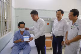 Tổng Giám đốc Bảo hiểm Xã hội Việt Nam Nguyễn Thế Mạnh tặng thẻ Bảo hiểm Y tế cho người dân. (Ảnh: PV/Vietnam+)