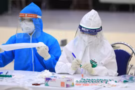 Nhân viên y tế của quận Cầu Giấy, Hà Nội đánh số và tên tuổi các mẫu xét nghiệm PCR của người dân từ Đà Nẵng trở về. (Ảnh: Thành Đạt/TTXVN)