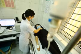Bác sỹ khám sàng lọc bệnh sốt xuất huyết cho một trường hợp tại Hà Nội. (Ảnh: PV)