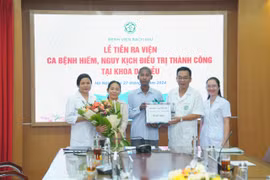 Các bác sĩ chúc mừng bệnh nhân đã kiên cường cùng các thầy thuốc để chiến thắng bệnh tật. (Ảnh: PV/Vietnam+)