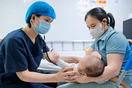 Bác sĩ khám cho bệnh nhi gần 2 tháng tuổi mắc ho gà điều trị tại Bệnh viện Nhi Trung ương. (Ảnh: Minh Quyết/TTXVN) 
