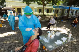 Nhân viên y tế lấy mẫu xét nghiệm cho người dân phường Nghĩa Đô. (Ảnh: Vũ Sinh/TTXVN)