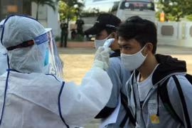 Đo thân nhiệt cho người cách ly. (Ảnh: PV/Vietnam+)