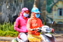 Người ra đường luôn mặc áo chống nắng để tránh sốc nhiệt. (Ảnh: Tuấn Đức/TTXVN)