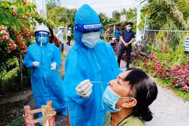 Nhân viên tại y tế cơ sở lấy mẫu xét nghiệm cho người dân. (Ảnh: PV/Vietnam+)
