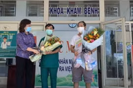BN936 và đại diện Trung tâm Y tế Hòa Vang nhận hoa nhân sự kiện bệnh nhân COVID-19 cuối cùng được điều trị khỏi tại Đà Nẵng. (Ảnh: PV/Vietnam+)