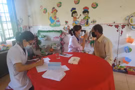Các bác sỹ khám bệnh và tặng quà cho các gia đình chính sách. (Ảnh: PV/Vietnam+)