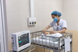 Nhân viên y tế chăm sóc cho trẻ sơ sinh tại Bệnh viện Đa khoa Đức Giang. (Ảnh: PV/Vietnam+)