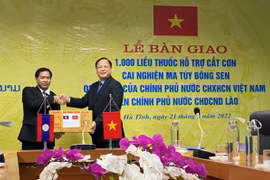Đại diện Chính phủ Việt Nam trao tặng thuốc cho đại diện Chính phủ Lào. (Ảnh: PV/Vietnam+)