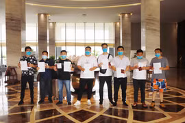 Các công dân Trung Quốc nhận giấy chứng nhận đủ thời hạn cách ly tại Vĩnh Phúc. (Ảnh: Hoàng Hùng/TTXVN)