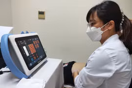 Bác sỹ siêu âm theo dõi sức khoẻ cho một bệnh nhân. (Ảnh: TTXVN phát)