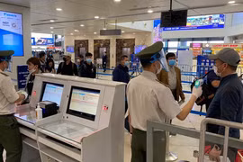 Nhân viên an ninh hàng không kiểm tra hành khách khi làm thủ tục hàng không để lên máy bay. (Ảnh: CTV/Vietnam+)