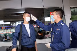 Đo thân nhiệt tại cửa soát vé tại bến xe Nước Ngầm, Hà Nội. (Ảnh: Danh Lam/TTXVN)