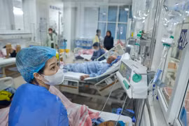 Điều dưỡng viên Thanh Bình chăm sóc bệnh nhân tại các buồng bệnh. (Ảnh: Minh Quyết/TTXVN)