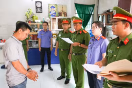 Cơ quan Điều tra tống đạt quyết định khởi tố bị can, lệnh bắt tạm giam đối với Nguyễn Văn Tuấn. (Ảnh: TTXVN phát)
