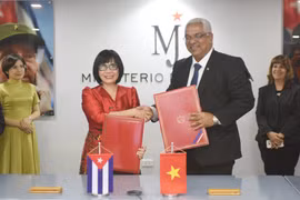 Thứ trưởng Đặng Hoàng Oanh (trái) và Bộ trưởng Tư pháp Cuba Oscar Manuel Silvera Martínez trao đổi Bản ghi nhớ về hợp tác. (Ảnh: Việt Hùng/TTXVN)