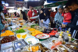 Người dân mua thực phẩm tại khu chợ ở Narathiwat (Thái Lan). (Ảnh: AFP/TTXVN)