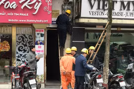 Nhân viên EVN Hà Nội đang chốt chỉ số côngtơ của khách hàng. (Ảnh: Đức Duy/Vietnam+)