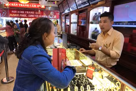 Khách hàng giao dịch vàng miếng tại Bảo Tín Minh Châu. (Ảnh: Đức Duy/Vietnam+)