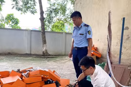 Lực lượng chức năng kiểm tra hàng hóa có dấu hiệu giả mạo nhãn hiệu HERMÈS. (Ảnh: PV/Vietnam+)