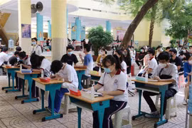 Học sinh ngồi giãn cách tại khu vực điền thông tin cá nhân trước khi vào lấy mẫu tại điểm Trường Tiểu học Nguyễn Bỉnh Khiêm (Quận 1). (Ảnh: Thu Hương/TTXVN)
