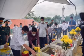Thắp hương tưởng niệm tại nghĩa trang liệt sỹ Quốc gia Vi Xuyên, Hà Giang. (Ảnh: Lê Hoàn/Vietnam+)
