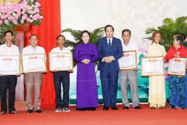 Chủ tịch Quốc hội Nguyễn Thị Kim Ngân và Bộ trưởng Bộ Lao động Thương binh xã hội Đào Ngọc Dung trao Bằng Tổ quốc ghi công cho thân nhân các gia đình. (Ảnh: Trọng Đức/TTXVN)