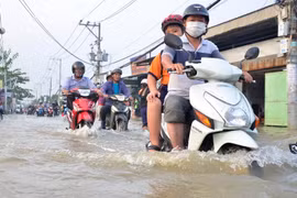 Triều cường làm ngập sâu trên đường Lê Văn Lương (huyện Nhà Bè). (Ảnh: Mạnh Linh/TTXVN)