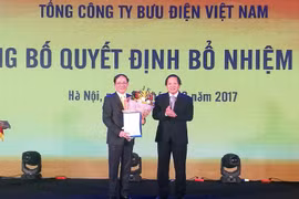 Bộ trưởng Bộ Thông tin và Truyền thông Trương Minh Tuấn (phải) trao Quyết định bổ nhiệm Chủ tịch VietnamPost. (Ảnh: PV/Vietnam+)