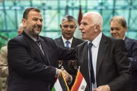 Trưởng đoàn đàm phán của Hamas, ông Saleh al-Aruri (trái) và Trưởng đoàn đàm phán của Fatah, ông Azzam al-Ahmad (phải) sau lễ ký thỏa thuận hòa giải tại Cairo, Ai Cập ngày 12/10/2017. (Nguồn: AFP/TTXVN)