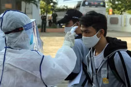 Đo thân nhiệt cho người cách ly. (Nguồn: TTXVN)