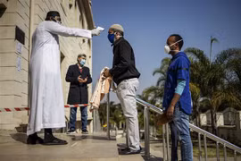 Kiểm tra thân nhiệt phòng lây nhiễm COVID-19 tại Midrand, Johannesburg, Nam Phi. (Ảnh: AFP/TTXVN)