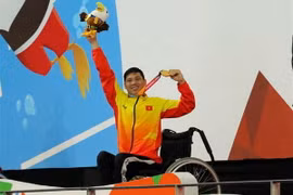 Vận động viên Võ Thanh Tùng tự hào giơ cao tấm Huy chương vàng thứ 3 tại Asian Para Games 2018. (Ảnh: Hải Ngọc/TTXVN)