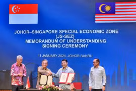 Bộ trưởng Kinh tế Malaysia Rafizi Ramli (thứ 2 từ phải sang) và Bộ trưởng Thương mại và Công nghiệp Singapore Gan Kim Yong ký biên bản ghi nhớ thành lập Đặc khu Kinh tế Johor-Singapore. (Nguồn: Bernama)